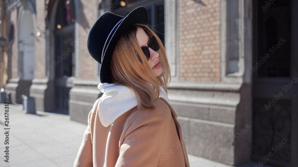 Fototapeta premium Charming young blonde on a walk. Young beautiful woman in stylish look