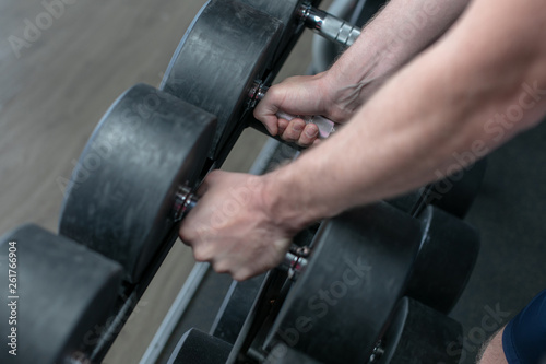 Colorful images. Hands holding dumbbells in the gym.