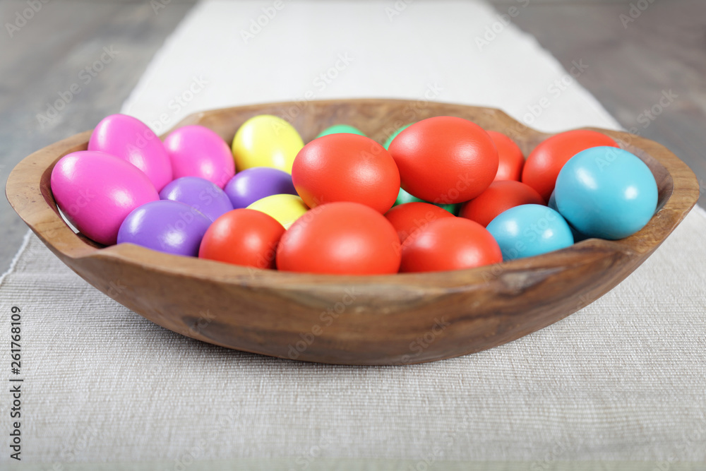 Multicoloured Easter eggs in a large wooden bowl Multicoloured Easter eggs in a large wooden bowl