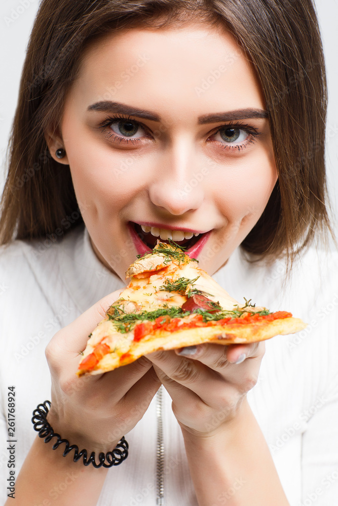 Young woman eats pizza, isolated on isolated on white background. Young woman eats pizza, isolated on isolated on white background.