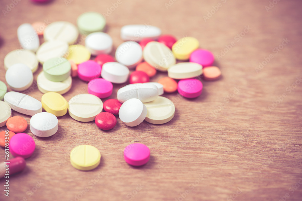 many color of pills on wood background