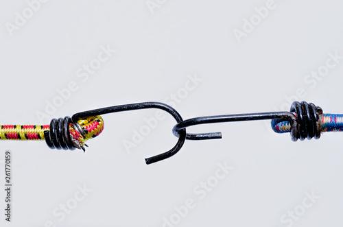 Fotografija Two bungee elasticated cords linked together with metal hooks isolated on white background