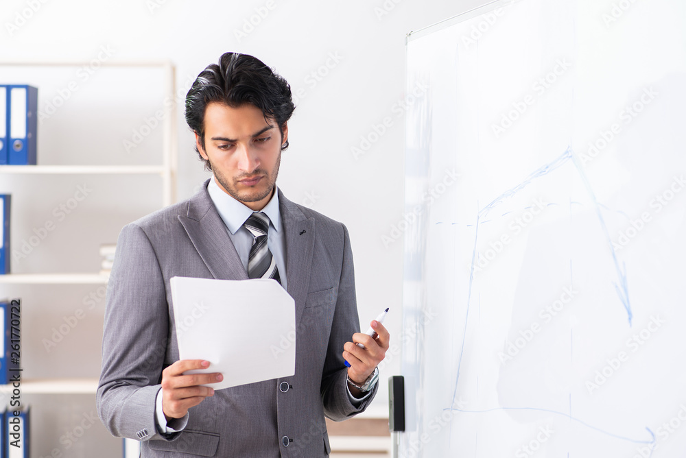 Young handsome businessman in front of whiteboard Young handsome businessman in front of whiteboard