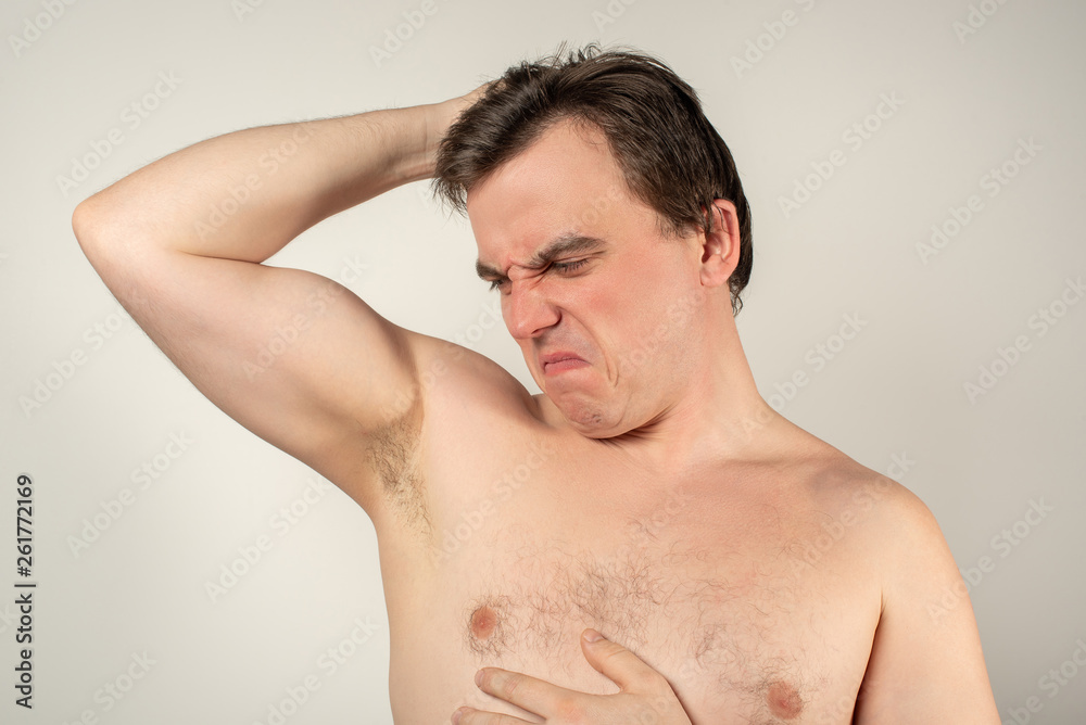 Handsome man with smelly armpits on a white background Handsome man with smelly armpits on a white background