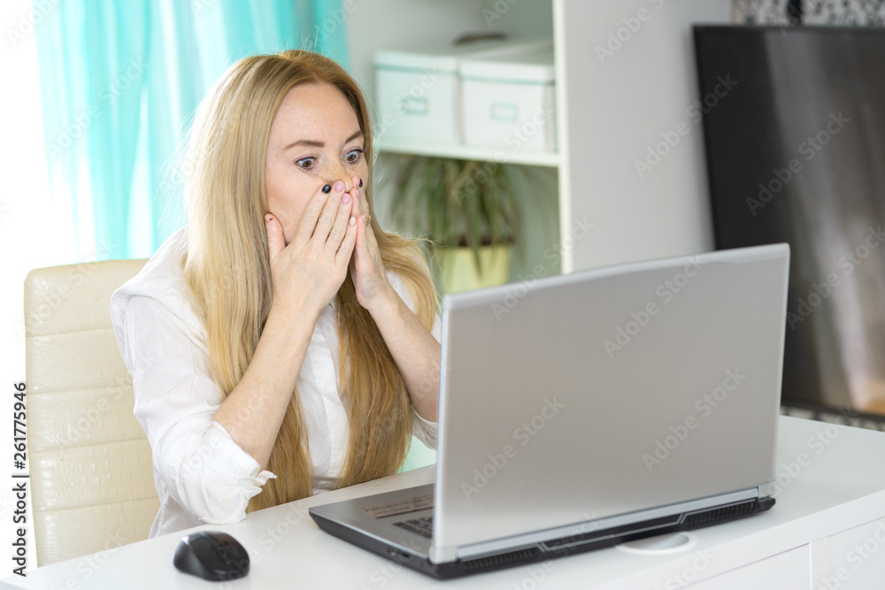 Portrait young shocked business woman sitting in front of laptop computer looking at screen isolated grey wall background. Funny face expression emotion feelings problem perception reaction Portrait young shocked business woman sitting in front of laptop computer looking at screen isolated grey wall background. Funny face expression emotion feelings problem perception reaction