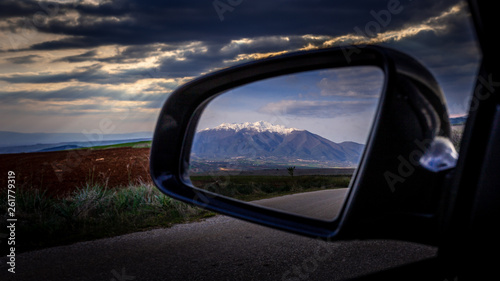 Mountain with cloudy sky in reflection of a side car mirror, Macedonia, Greece,