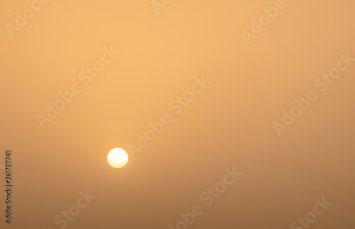 Abstract monochrome minimalistic image of the sun in front of a yellow sky, background