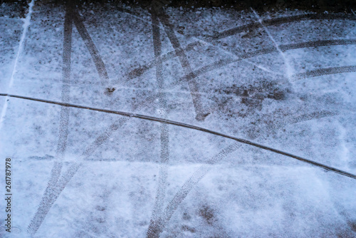 car tyre traces on parking spot in winter - top down photo