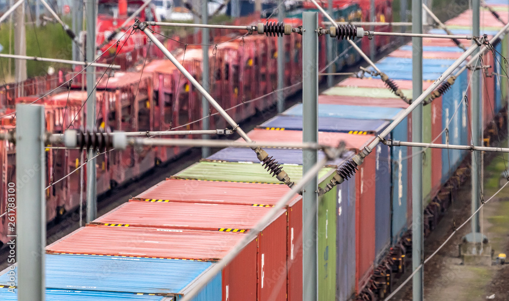 Telephoto recording of a freight wagon on the rails with coloured containers