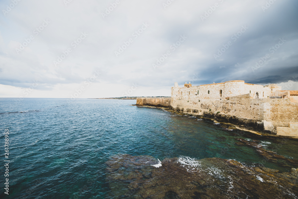 Beautiful view of Maniace castle in Ortigia Syracuse, in front of the sea and sky.