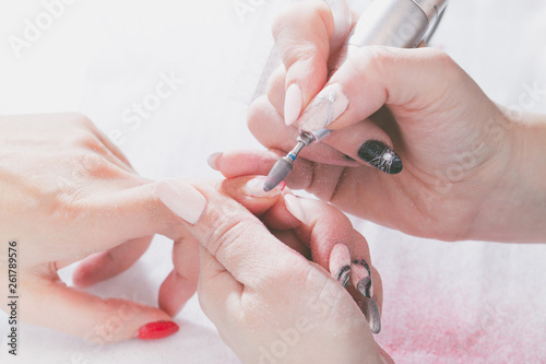The hands of the master of manicure and the hands of the client close-up during the nail design process.