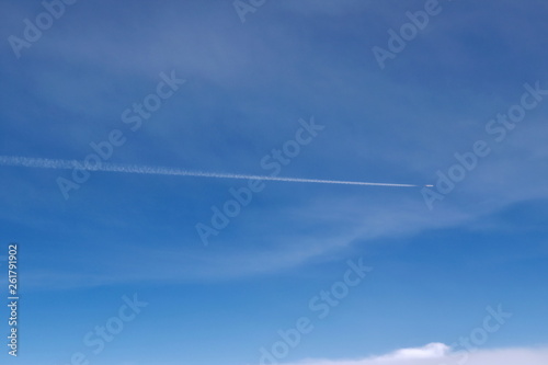 airplane flying make condensation tail on sky in sunshine day
