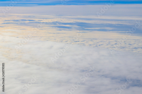 Beautiful white clouds in blue sky. View from airplane