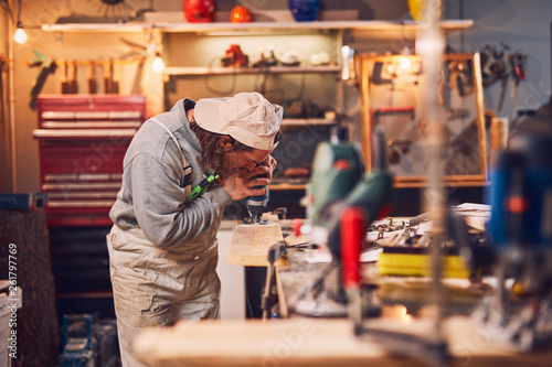 Male carpenter working on old wood in a retro vintage workshop.