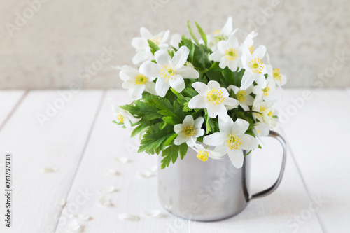Bunch of white spring flowers in iron mug
