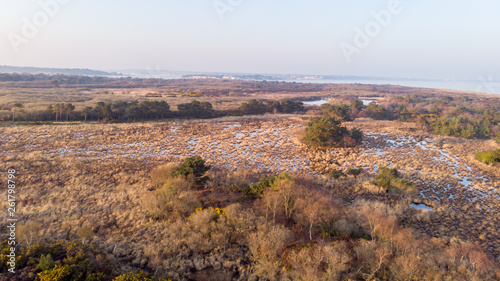 An aerial view of the Studland Nature Reserve with sand dune  peat bog and sea under a majestic hazy blue sky