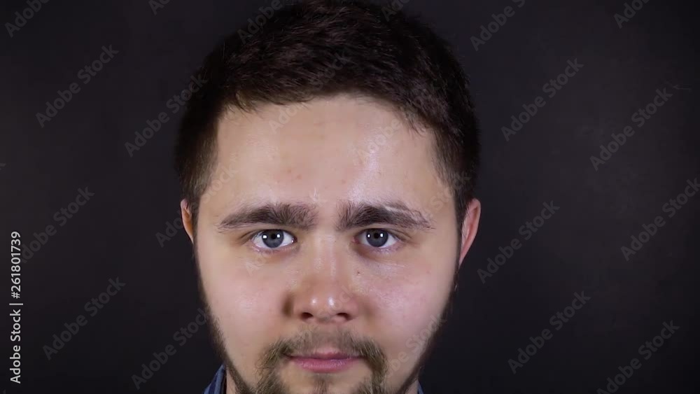 A young man is looking at the camera and smiling. Close-up face shot. A young man is looking at the camera and smiling. Close-up face shot.