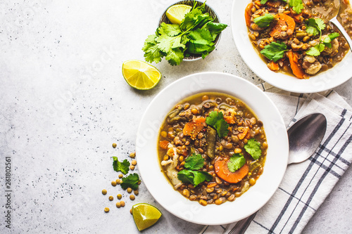 Lentil soup with vegetables in a white plate, white background. Plant based food, clean eating.