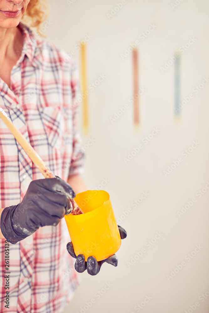 Working woman plastering / painting walls inside the house. Working woman plastering / painting walls inside the house.