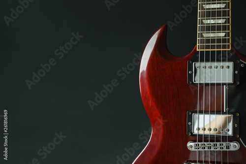Beautiful six - string electric guitar against dark background, space for text