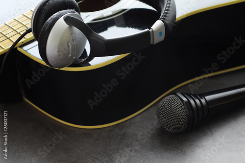 Guitar and accessories on a stone background. Desk musician, headphones, microphone. photo