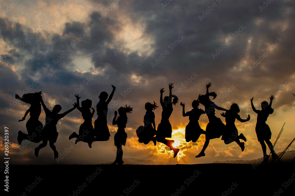 Silhouettes of young group of people jumping on the hill Silhouettes of young group of people jumping on the hill