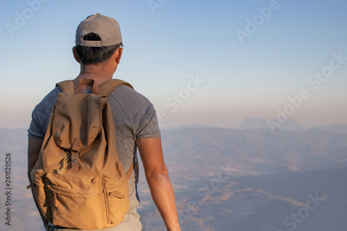 Adventure young man hiking in the mountains with a backpack.