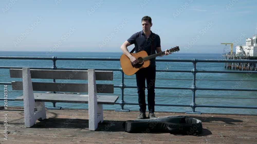 Street performer gives up for the day and packs up his guitar. Street performer gives up for the day and packs up his guitar.