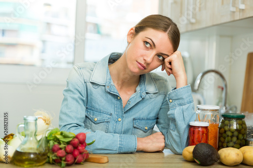 Tired woman sitting at home kitchen