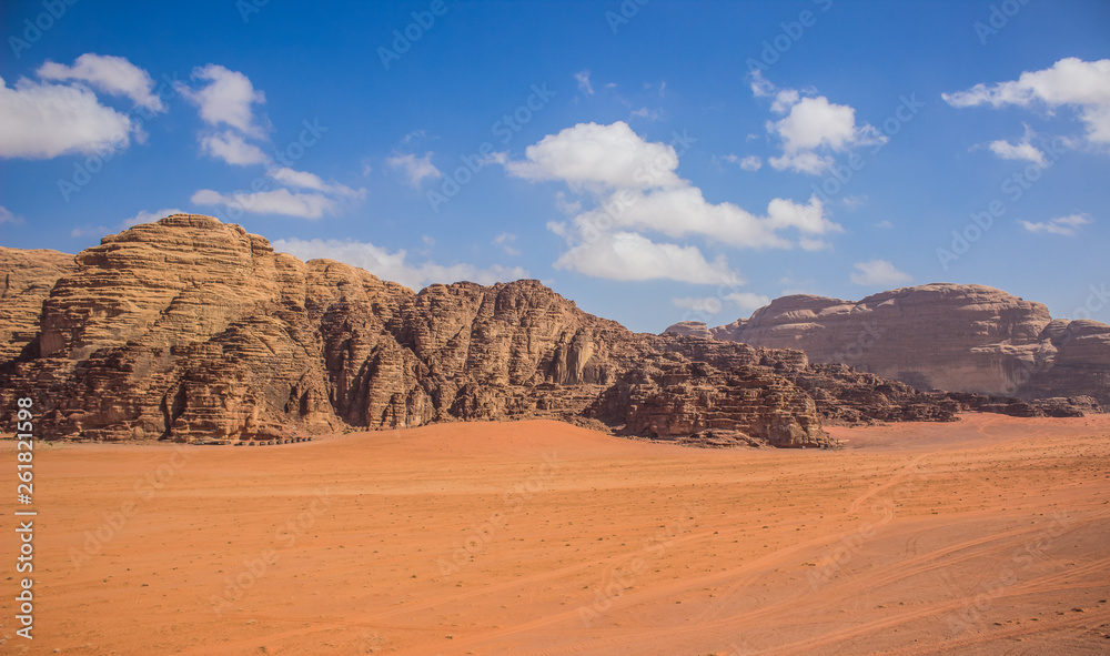 Wadi Rum Jordan Middle East panorama scenery desert landscape sand valley foreground and bare rocky mountain ridge background with vivid blue sky, travel planet and discovery  concept photography