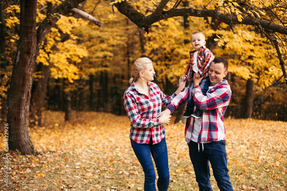 Fototapeta premium Little cute son playing with parents in forest