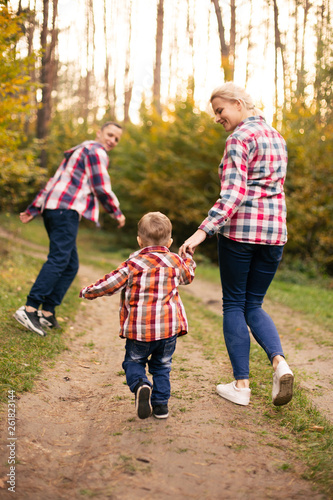 Little cute son playing with parents in forest