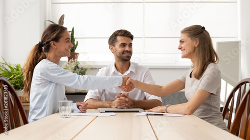 Happy female business partners handshake sign contracts with lawyer mediation photo
