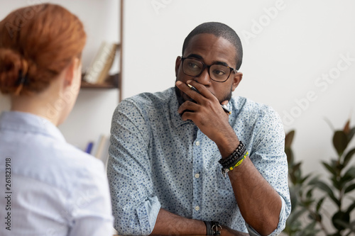 Obraz na plátně Doubtful african hr talking to caucasian applicant at job interview
