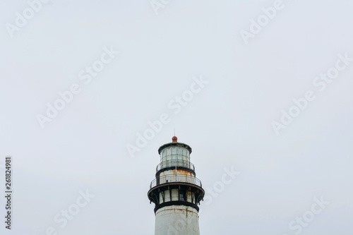 Weathered lighthouse on California’s Pacific Ocean coast during overcast in the daytime