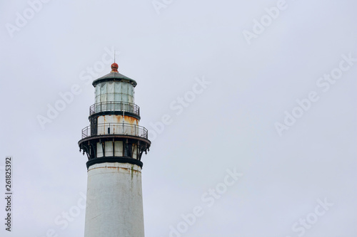 Weathered lighthouse on California’s Pacific Ocean coast during overcast in the daytime