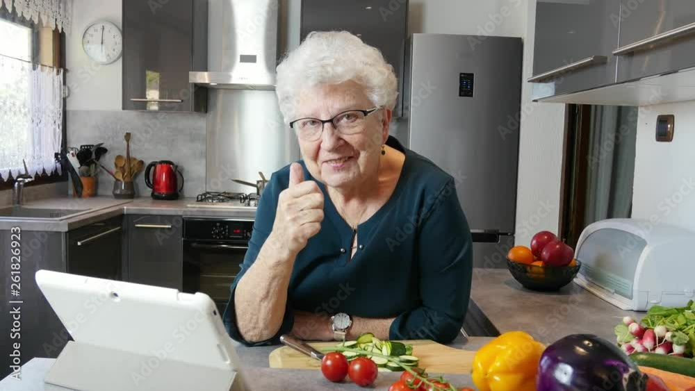 happy senior active woman cooking at home in a modern kitchen happy senior active woman cooking at home in a modern kitchen