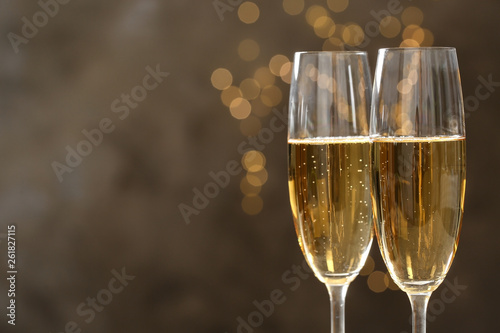 Glasses of champagne on blurred background, closeup. Space for text