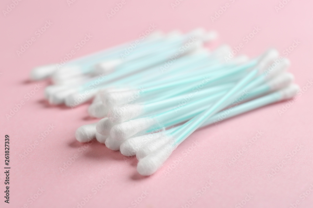 Pile of cotton swabs on color background, closeup Pile of cotton swabs on color background, closeup