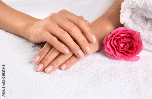 Closeup view of beautiful female hands and rose on towel. Spa treatment