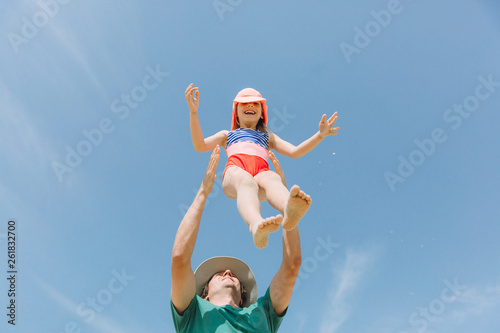 Father playing with happy little daughter outdoor on sunny day