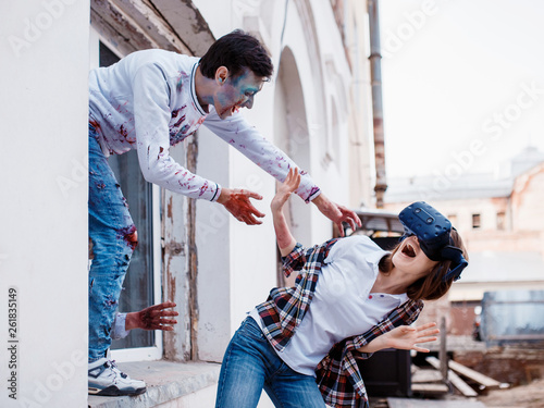 Concept, the girl plays video games about zombies, wearing virtual reality glasses. zombie makeup