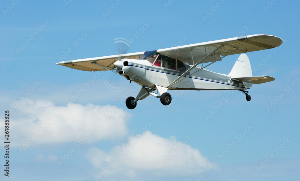 Small sports airplane hovering highly in the sky outdoor