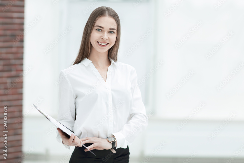 Executive business woman with clipboard against the background of bright office Executive business woman with clipboard against the background of bright office