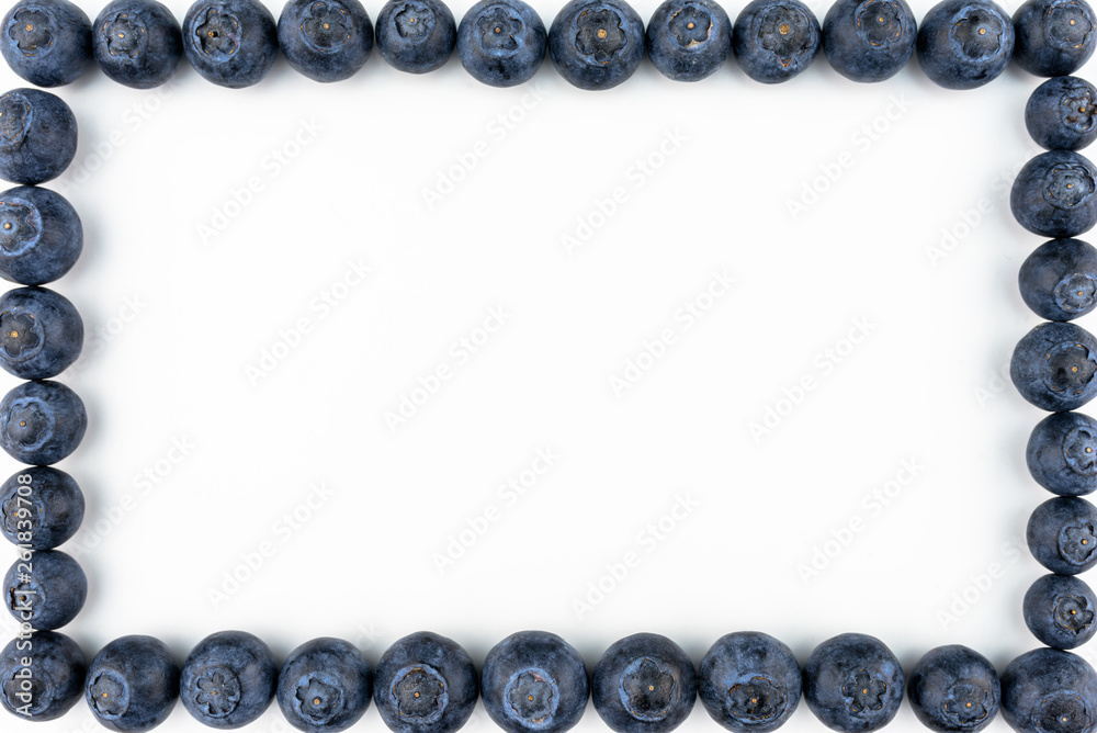 Frame made from fresh blueberries, top view, flat lay, isolated on a white background with copy space in the middle.