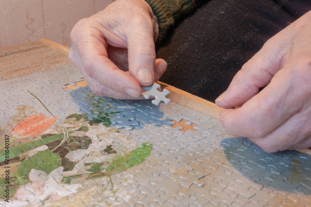 Hands puts a puzzle on the table. We love puzzles. Hands puts a puzzle on the table. We love puzzles.