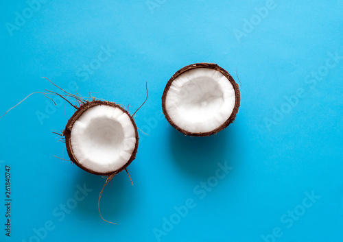 Broken Coconut isolated on a blue background. Border design. Fresh raw organic half of coco nut. Healthy Food, skin care concept. Vegan food