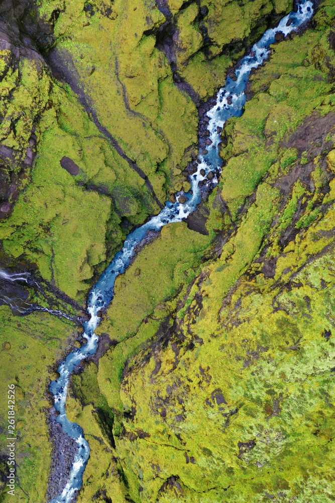 Aerial View Looking Down on Blue Stream Winding Through Green Hilled Ravine Aerial View Looking Down on Blue Stream Winding Through Green Hilled Ravine
