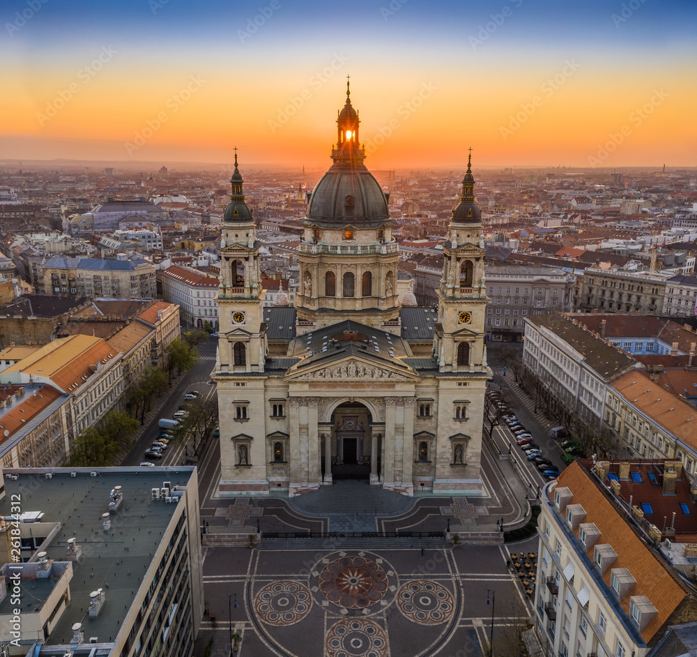 Fototapeta premium Budapest, Hungary - Aerial view of famous St. Stephen's Basilica in the morning with golden amd blue sky and rising sun at right behind the building