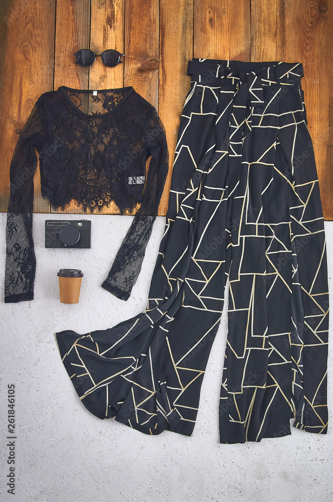 Beautiful unusual outfit presentation for fashion blog, advertising,  clothing catalog. Fashionable stylish evening look. Geometric pattern wide  black pants and a long sleeve mesh lace top. Stock Photo | Adobe Stock